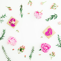 Floral round frame of pink peonies, roses, hypericum and eucalyptus branches and gifts on white background. Valentine day composition. Flat lay, top view