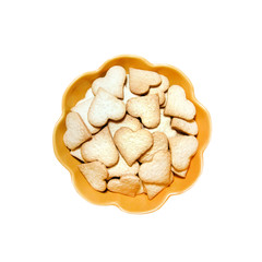 Ginger cookies in the shape of heart in a yellow bowl isolated on white background with clipping path