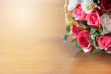 Close up rose bouquet with green leaves on wooden table