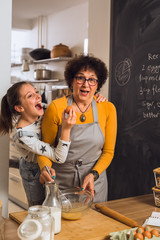 senior woman and her granddaughter cooking in kitchen