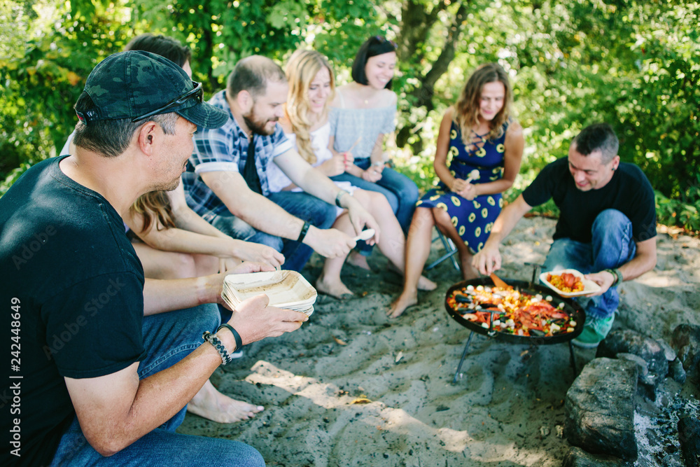 Wall mural Happy people having a pic-nic. Group of friends making barbecue in the nature. Concept about good and positive 