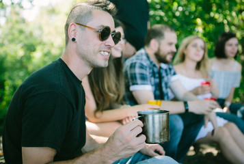 Happy people having a pic-nic. Group of friends making barbecue in the nature. Concept about good and positive 