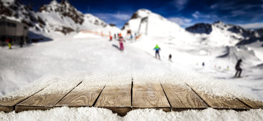 Wooden desk space and winter landscape of mountains in Alps 