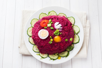 layered salad with herring and beets, carrots and potatoes and eggs close-up on a plate. horizontal copy space