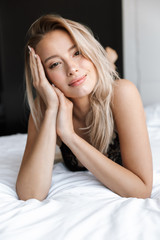 Obraz premium Young woman in lingerie underwear lies in bed at home.