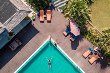 drone view pool man swimming pool Myanmar Asia, couple men and woman by the pool view from above...