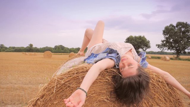 Beautiful caucasian woman lying on her back on haystack