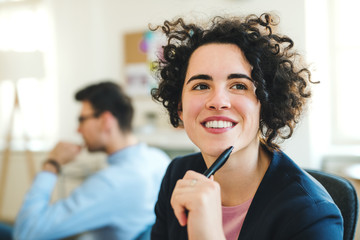 A portrait of young businesswoman with colleagues in a modern office.
