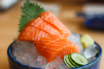 Raw salmon slice or salmon sashimi on ice with fresh wasabi in Japanese style fresh serve.