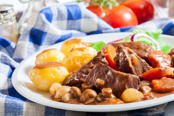 Beef Bourguignon stew served with baked potatoes