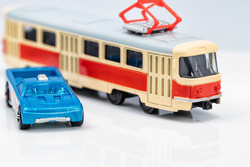 Fototapeta premium Toy red and yellow tram and toy blue car