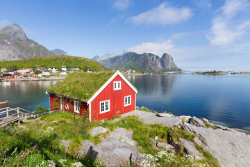 Fototapeta na wymiar View of traditional norwegian red hut in Lofoten islands. Beautiful summer day and blue sky.