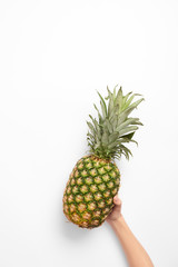 cropped view of woman holding organic pineapple in hand on white background