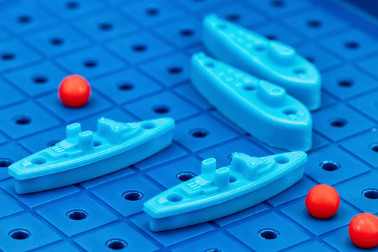 Toy war ships and submarine are placed on the blue  playing Board