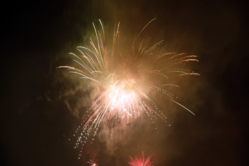 Exploding firework and foggy dark night sky New Years Eve celebration.