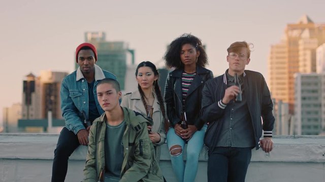 group of young diverse friends hanging out on rooftop at sunset looking confident in urban city gen z concept