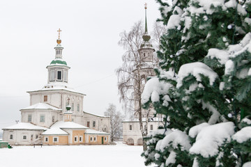 Russian orthodox church, the bell tower and christmas tree in the winter among the white snow. Veliky Ustyug, Russia