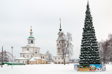 Russian orthodox church, the bell tower and christmas tree in the winter among the white snow. Veliky Ustyug, Russia