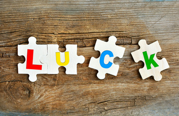 Luck concept. Puzzles with letters on a wooden background. Concept of building luck.
