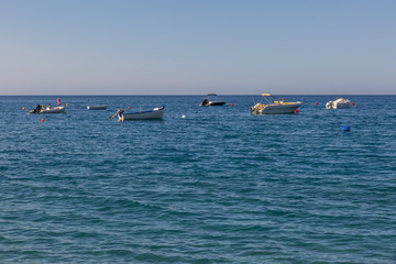 Far view of some small yachts in the sea near the beach