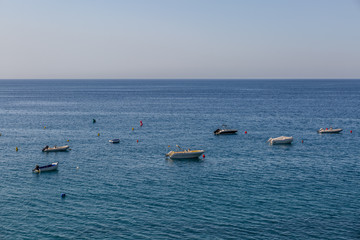 Obraz premium Far view of some small yachts in the sea near the beach