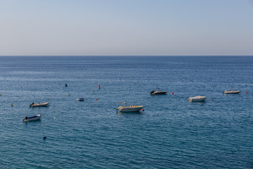 Far view of some small yachts in the sea near the beach