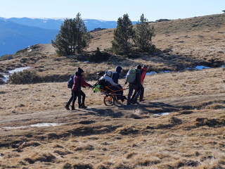 Randonn&eacute;e de la solidarit&eacute; avec fauteuil roulant joelette pour handicap&eacute; dans les pyr&eacute;n&eacute;es 