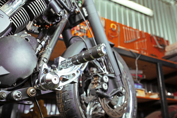 Fototapeta na wymiar Cropped close up shot of beautiful and custom made motorcycle in the workshop