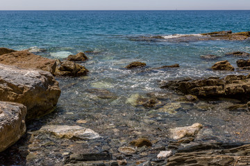 Big rocks on the shore of a crystal clear water beach