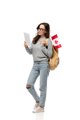 female student in glasses holding canadian flag and using digital tablet isolated on white