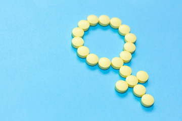 Gender woman symbol icon of yellow pills on blue background. Girl Sign. Medical concept