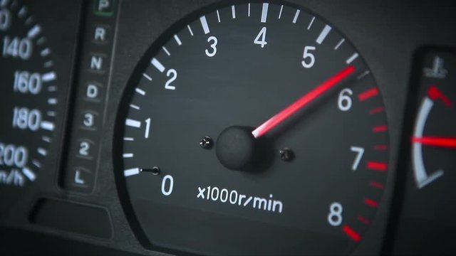 Car tachometer with red moving pointer.
