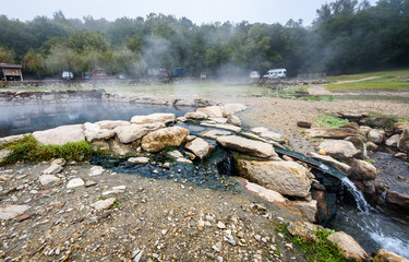 Natural Roman baths outdoors with hot steam and thermal water.