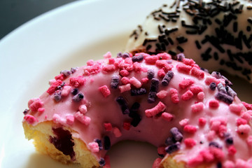 Delicious donuts on a white plate. Pink and white donut close up