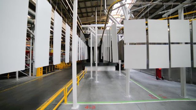 Powder coating line. Metal panels are suspended on an overhead conveyor line.