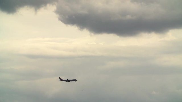 Airplane landing amid storm clouds