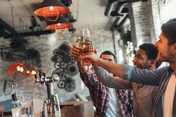 Guys drinking beer for meeting in bar