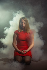 girl sitting on a black background with smoke