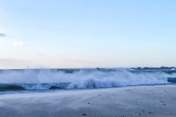 Waves crashing on the beach on a summer evening at Camps bay in Cape Town, South Africa
