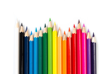 Colour pencils on white background, top view.