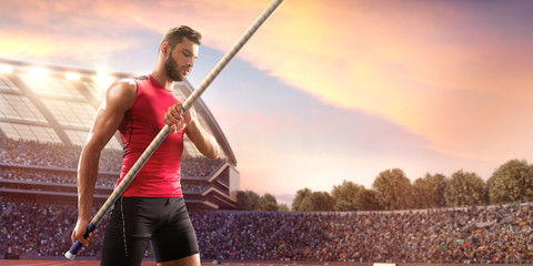 Young male pole vault athlete with pole bar. Men in sport clothes at athletic sport track in professional stadium - obrazy, fototapety, plakaty