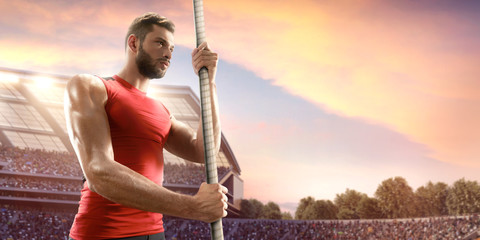 Young male pole vault athlete with pole bar. Men in sport clothes at athletic sport track in...