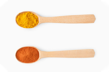 Wooden spoons with aromatic culinary condiments on white