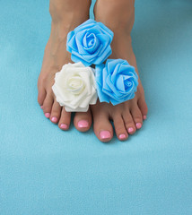 Healthy and elegant well-groomed female feet with the flowers