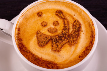 The drawing of a bear from cinnamon in a cup with coffee