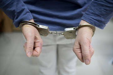 Closeup view of handcuffed man rising his hands.