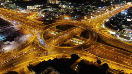 Fototapeta na wymiar Aerial hyperlight night shot of illuminated multilevel ring junction road passing through city center interconnecting 3 motorways