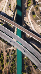 Aerial bird's eye view photo taken by drone of Corinth Canal of Isthmos or Isthmus and road network motorway connecting mainland with Peloponnese, Greece