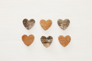 Valentine's day concept. hearts cutted from tree trunk over wooden white background.