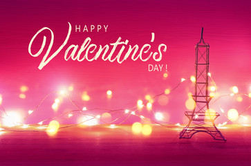 Valentine's day background. Eiffel tower over wooden table and purple bakground.